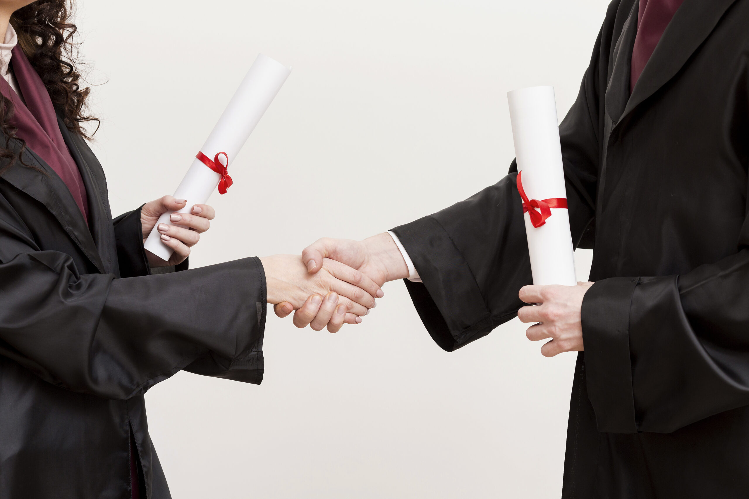close up graduates shaking hands